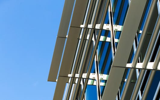 Nahaufnahme einer Gebäudefassade mit goldenen Metallträgern und Glas im Industriedesign